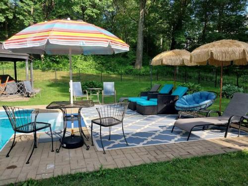 a patio with a table and chairs and an umbrella at 597b) Large 4 bedroom - Pool - Fire Pit in Wolcott