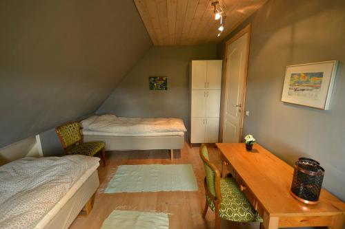 Pokój na poddaszu ze stołem, łóżkiem i biurkiem w obiekcie Kardybvej 8 w mieście Tastum
