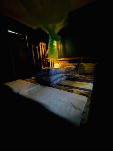 a dark room with two beds with white sheets at Moivaro Eco Hostel in Nkunjila