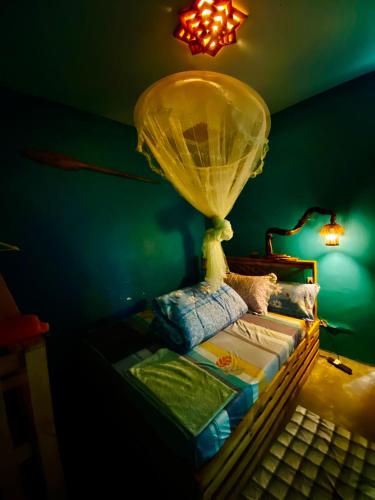 a bedroom with a bed with a lamp and a keyboard at Moivaro Eco Hostel in Nkunjila