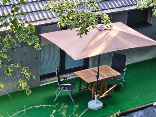 a table and chairs with an umbrella on a lawn at Cottage am Michelsberg in Bad Münstereifel