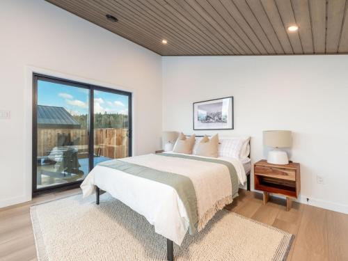 サセックスにあるLuxury Cabin with Private Hot Tub Minutes from Poley Mountain & Sussexのベッドと大きな窓のある寝室