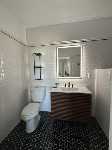 a bathroom with a toilet and a sink and a mirror at Retro-Chic Escape 208 in Klamath Falls