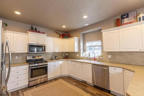 a kitchen with white cabinets and stainless steel appliances at Prime Location The Village Green Room Desk in Meridian