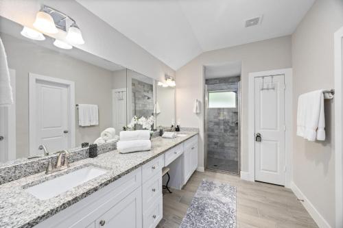 a bathroom with two sinks and a shower at Conroe 3BR Sleeps 12 | Fenced Yard + Garage Games in Conroe