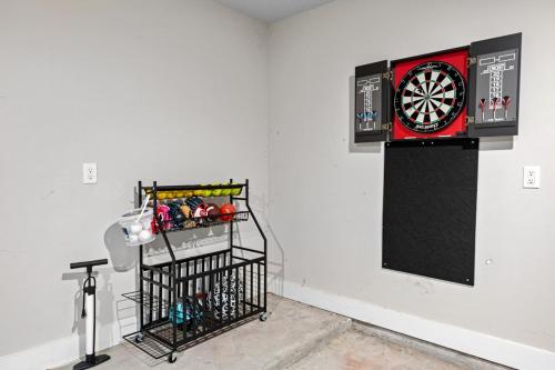 a dart board on a wall next to a wall at Conroe 3BR Sleeps 12 | Fenced Yard + Garage Games in Conroe