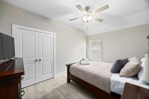 a bedroom with a bed and a ceiling fan at Conroe 3BR Sleeps 12 | Fenced Yard + Garage Games in Conroe