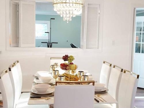 a dining room table with white chairs and a chandelier at 597) Sleeps 12 - Pool - Grill in Wolcott