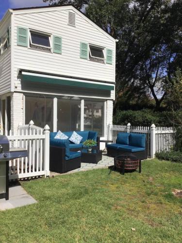 a white house with blue furniture in the yard at 597) Sleeps 12 - Pool - Grill in Wolcott