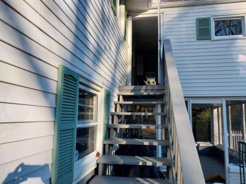 a staircase leading up to a house with green shutters at 597) Sleeps 12 - Pool - Grill in Wolcott