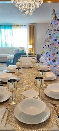 a living room with a christmas tree and plates on a table at 597) Sleeps 12 - Pool - Grill in Wolcott