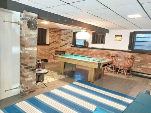 a pool table in a room with a brick wall at 597) Sleeps 12 - Pool - Grill in Wolcott