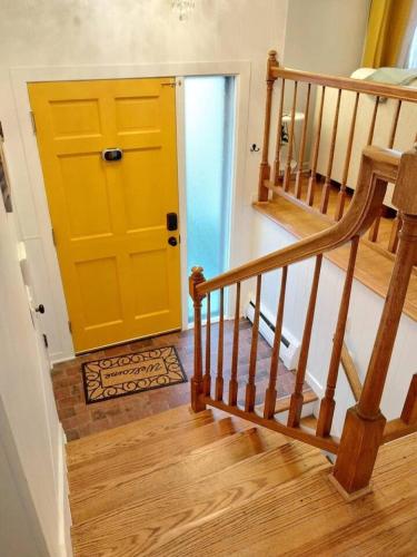 a yellow door in a room with a staircase at 597) Sleeps 12 - Pool - Grill in Wolcott
