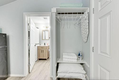 a hallway with a door leading into a bathroom with a closet at 2 Combined Homes - 2 Private Pools - 16 Guests in Austin