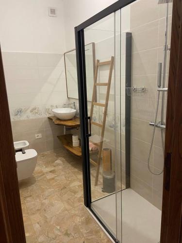a bathroom with a glass shower and a toilet at La Casa del Falegname in Ripatransone