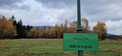 a green sign on a pole in a field at Babiogórskie Domki in Lipnica Wielka