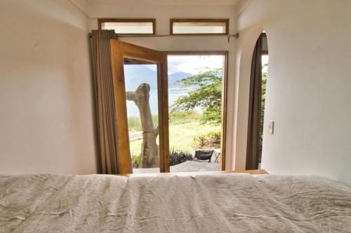 a bedroom with a bed and a window with a view at NEW Atitlan Lakefront, Casa Sabiduria in San Marcos La Laguna