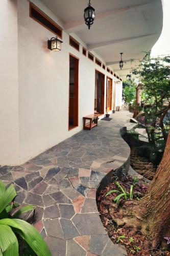 a stone walkway next to a building with a tree at NEW Atitlan Lakefront, Casa Sabiduria in San Marcos La Laguna