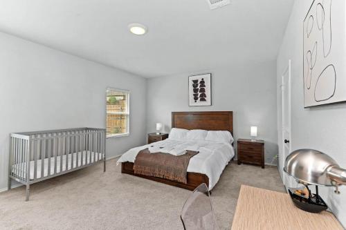 a bedroom with a large bed and a crib at Luxury Spacious GameRoom Sleeps 15 people in Austin