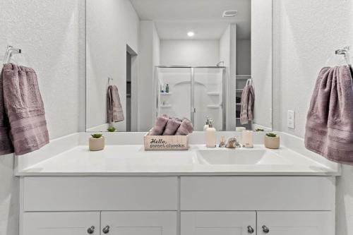 a white bathroom with a sink and a mirror at Luxury Spacious GameRoom Sleeps 15 people in Austin