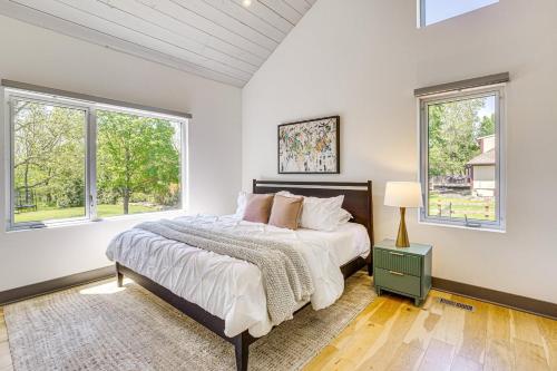 a bedroom with a large bed and two windows at Modern Oasis-lots Of Amenities Including A Pool! 