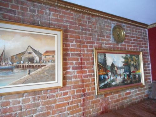 a brick wall with two paintings on it at Castel d'Amérique Française in Quebec City