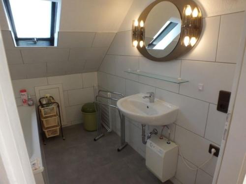 a bathroom with a sink and a mirror at Ferienwohnung Lange Obergeschoss in Maasholm-Bad