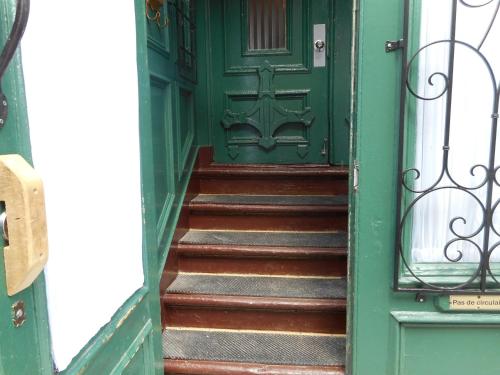 a green door with stairs in front of it at Castel d'Amérique Française in Quebec City