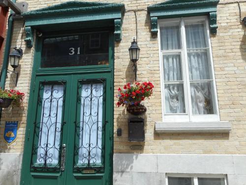 a green door and windows on a brick building at Castel d'Amérique Française in Quebec City