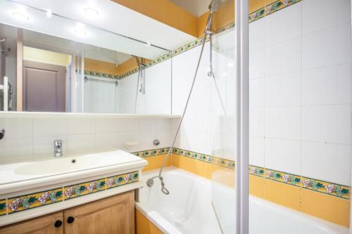 łazienka z wanną, umywalką i lustrem w obiekcie Les Appartements aux Restanques du Golfe de St Tropez - maeva Home - Appartement 2 Pièces 4 Personnes - Confort MAE-3354 w mieście Grimaud