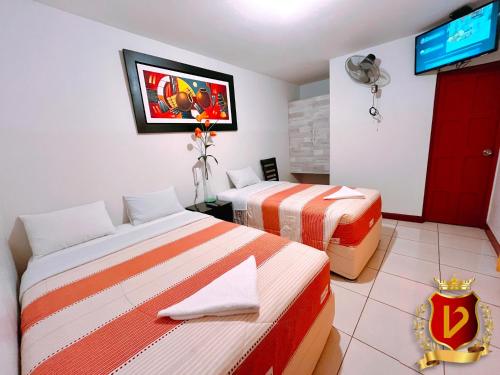 a hotel room with two beds and a tv at Veneccia Gold Hotel in Chiclayo