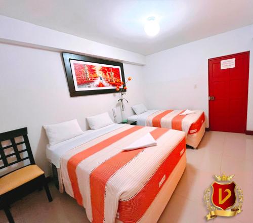 a hotel room with two beds and a red door at Veneccia Gold Hotel in Chiclayo
