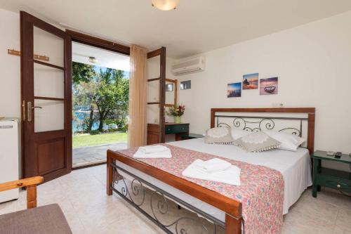 a bedroom with a bed and a sliding glass door at Pension Giannis Αdults only in Koinyra