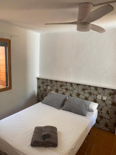 a bedroom with a white bed with a ceiling fan at Pink Lemon House in Elche