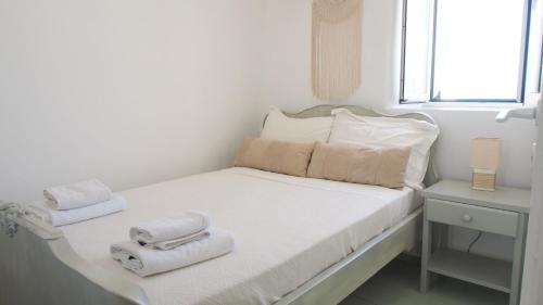 a white bed with towels on it in a room at Maria's traditional house in Naousa in Naousa