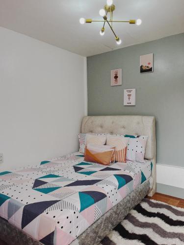 a bedroom with a bed with a colorful comforter at Casa de Descanso in Kiawagan