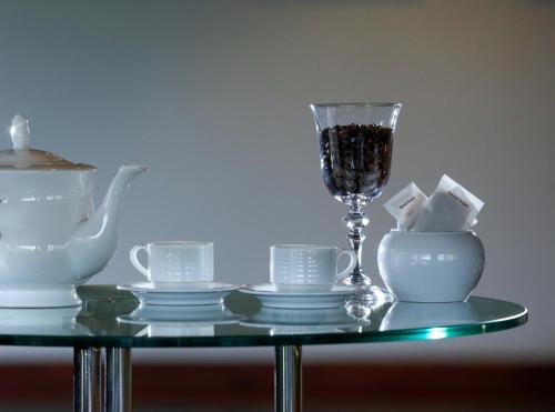 a glass table with tea cups and a wine glass at Sangrilla Bandarawela in Bandarawela