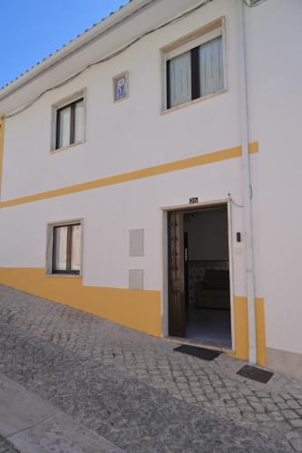 a white and yellow building with a large doorway at Casa do Areal in Alenquer