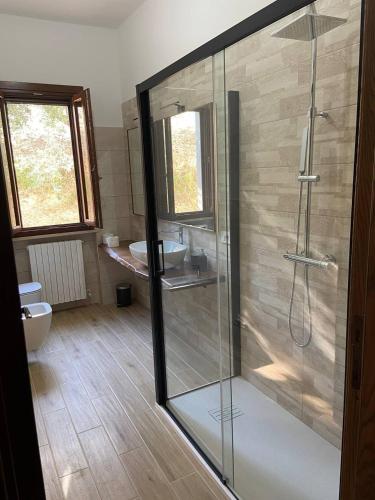 a bathroom with a glass shower and a toilet at La Casa del Falegname in Ripatransone