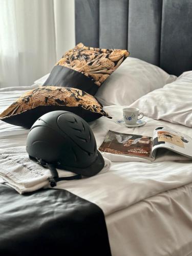 a bed with a helmet and a book on it at Folwark Nadmorska Ostoja in Mechelinki