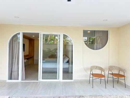 a room with a glass door with two chairs at Stanza Del Mar in Coveñas