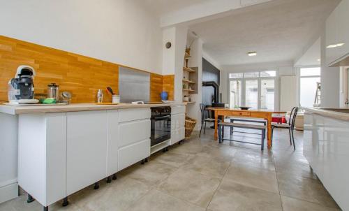 a kitchen with white cabinets and a table in it at Le chaource in Chaource