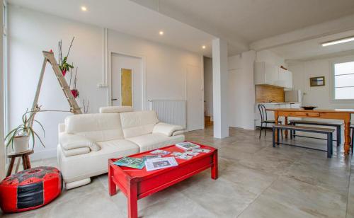 a living room with a white couch and a red table at Le chaource in Chaource