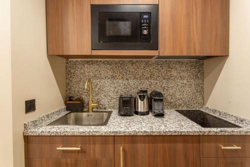 a kitchen with a sink and a microwave at Sol hotel St Mande - 2 personnes - 22 in Saint-Mandé