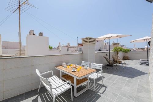 a patio with a table and chairs on a roof at Nueva 22 Suites in Nerja by Solaga Holiday Homes in Nerja