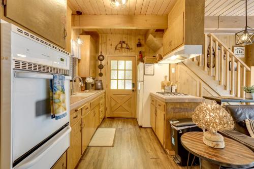 a kitchen with wooden cabinets and a white appliance at 2 Mi to Lake Arrowhead Pet-Friendly Cabin in Lake Arrowhead