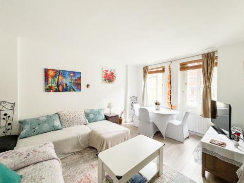 a living room with a couch and a table at Regents Park Camden St Johns Wood in London