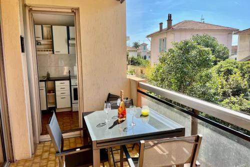 un balcon avec une table et des chaises et une cuisine dans l'établissement Bright T2 apartment 11 minutes from the beach, à Cagnes-sur-Mer