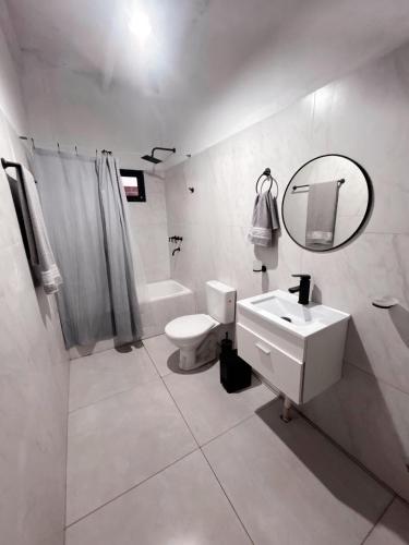 a bathroom with a sink and a toilet and a mirror at Casa con piscina y quincho in Candelaria