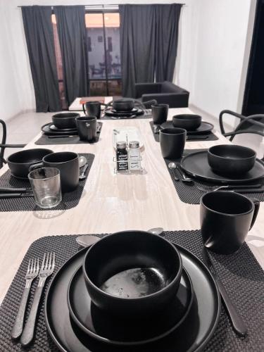 a table with black plates and utensils on it at Casa con piscina y quincho in Candelaria